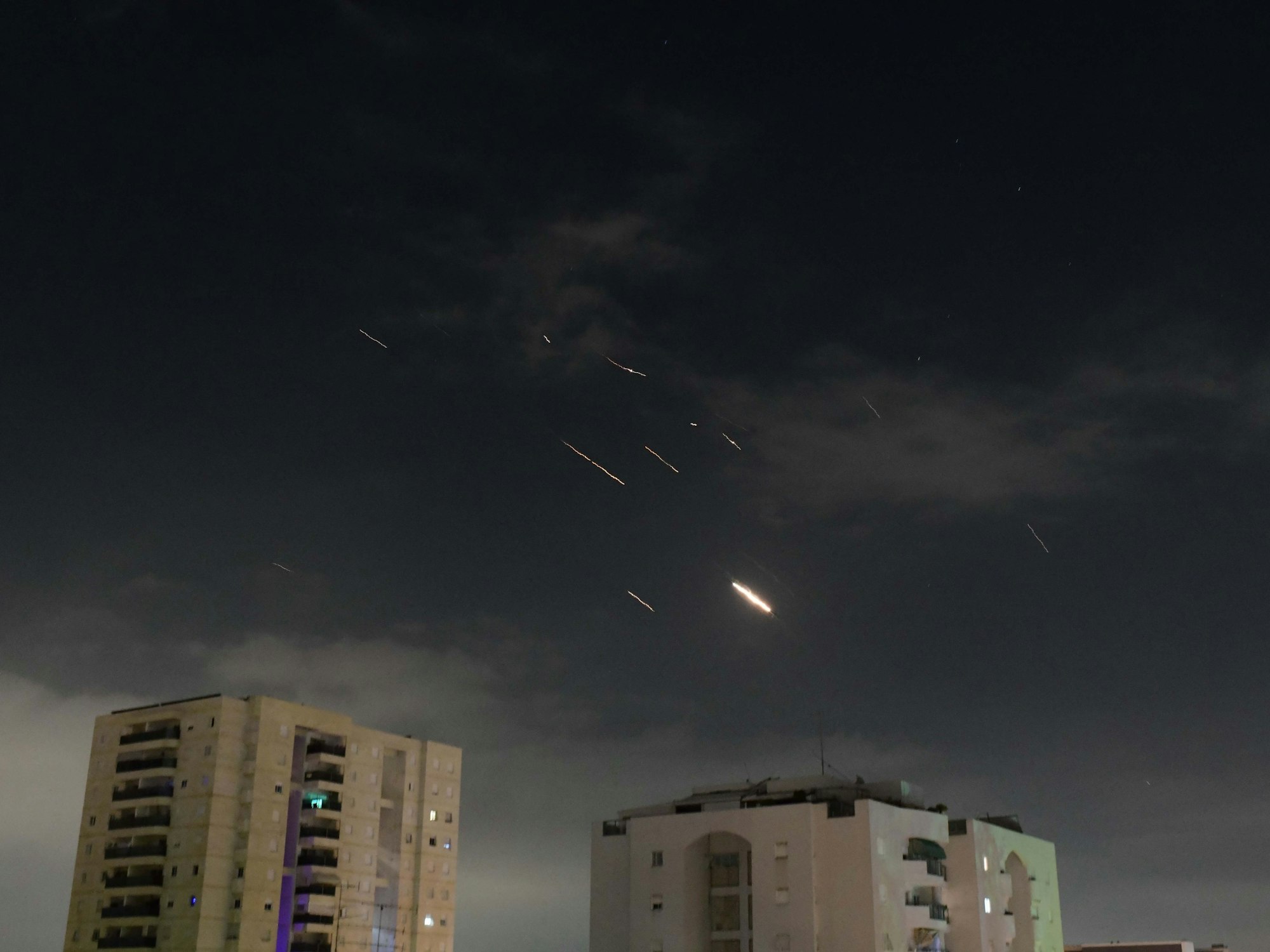 Flammen von Explosionen erscheinen am Himmel über Tel Aviv, während Israels Raketenabwehrsystem Raketen und Drohnen aus dem Iran abfängt.