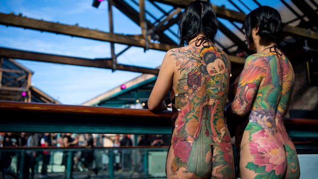 Zwei Frauen zeigen ihre Tätowierungen während einer Internationalen Tattoo Convention in London.