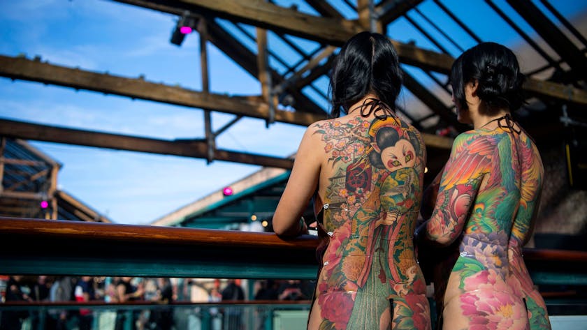 Zwei Frauen zeigen ihre Tätowierungen während einer Internationalen Tattoo Convention in London.