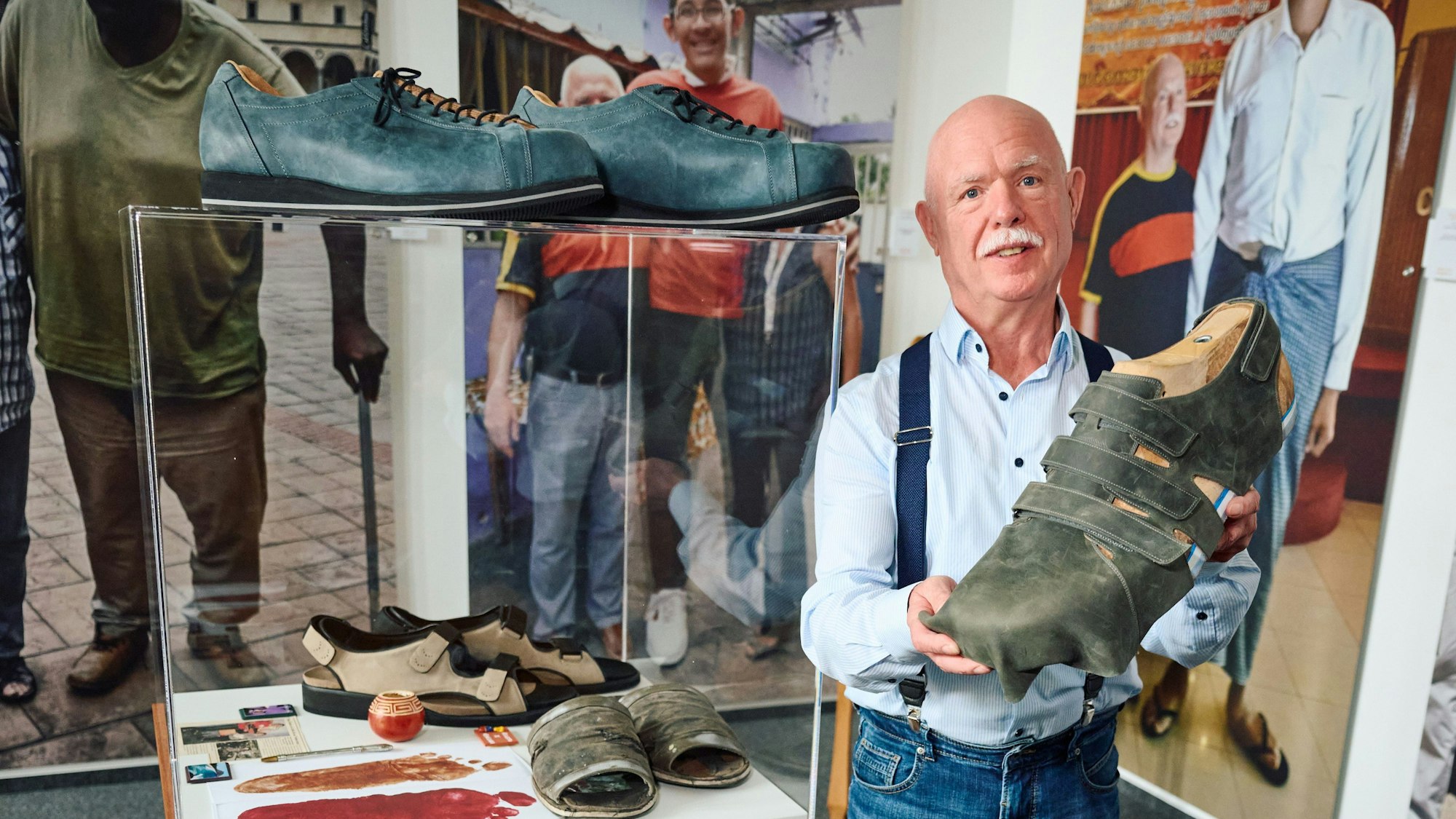 Schuhmacher Georg Wessels zeigt in seinem Geschäft die noch unfertigen neuen Schuhen für Jeison Rodriguez (auf dem Foto links hinter ihm).