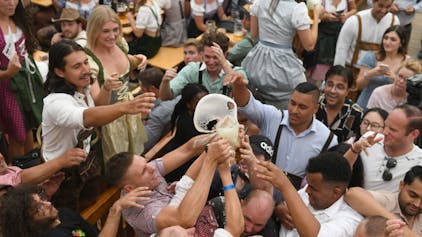 Gäste ringen beim Oktoberfest um eine Maß Bier. Die CSU hat durchgesetzt, dass auch künftig der Cannabis-Konsum auf bayerischen Volksfesten verboten ist. (Symbolbild)