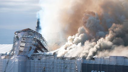 Rauch steigt bei einem Brand aus der Alten Börse „Boersen“ in Kopenhagen auf. Eines der ältesten Gebäude Kopenhagens steht in Flammen und seine ikonische Turmspitze ist eingestürzt.