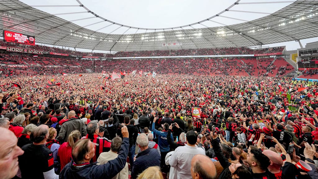 Fans von Bayer Leverkusen stürmen nach dem Gewinn der Deutschen Meisterschaft den Rasen in der BayArena.