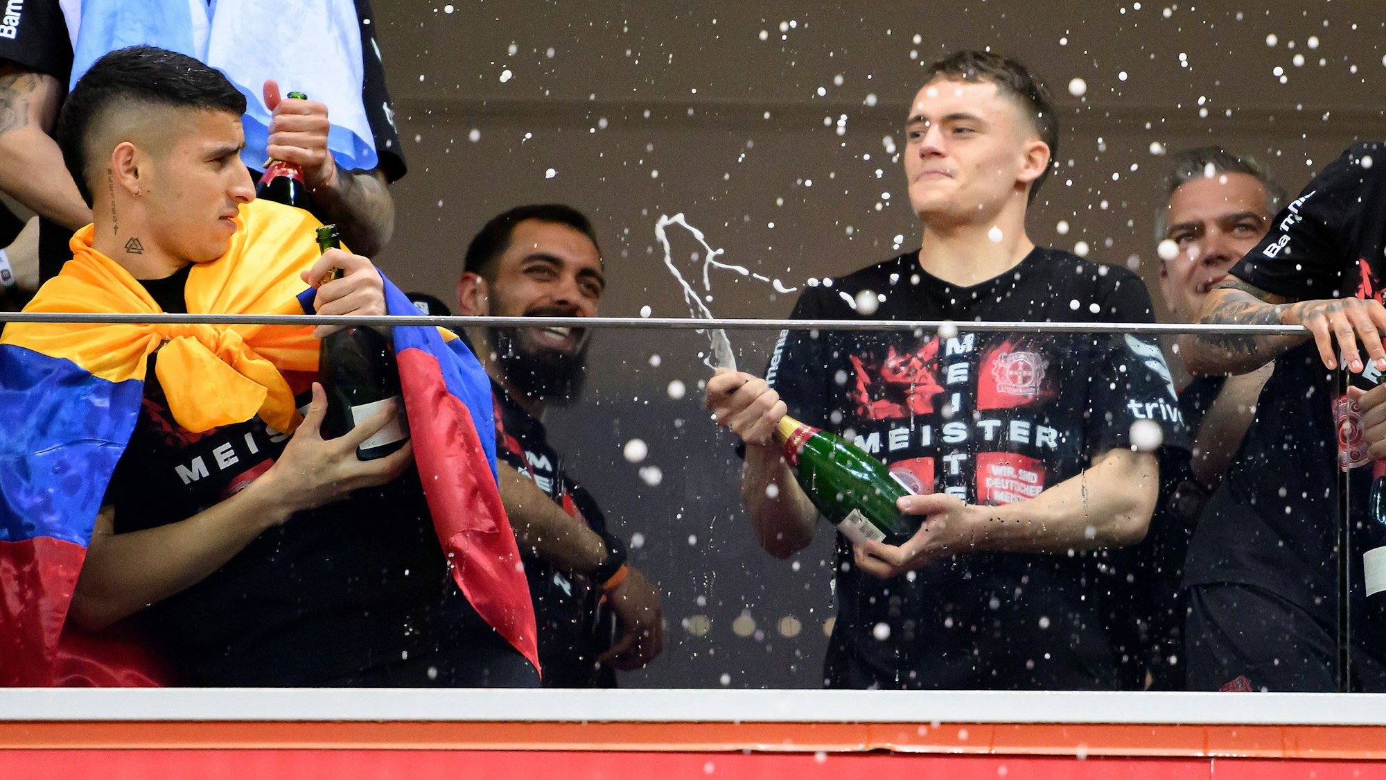 Florian Wirtz feiert mit seinen Kollegen Piero Hincapié (l.) und Borja Iglesias (hinten) die Meisterschaft von Bayer Leverkusen.