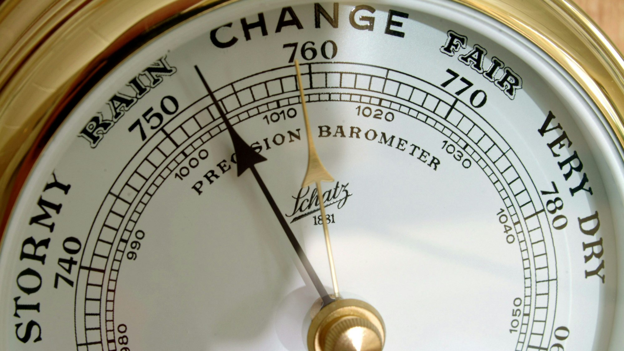 Ein altmodisches Barometer zeigt auf Englisch Luftdruck und Wetterlage an.