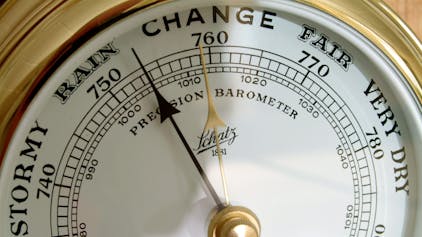 Ein altmodisches Barometer zeigt auf Englisch Luftdruck und Wetterlage an.