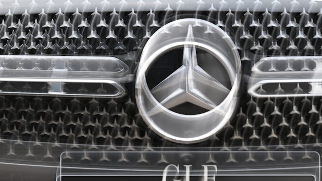 Das Logo der Automarke Mercedes-Benz ist an der Front eines Mercedes-Benz Fahrzeugs angebracht (Wischeffekt durch Langzeitbelichtung und Zoomen).