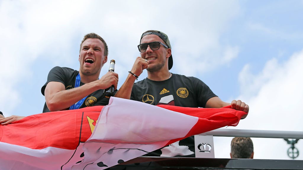 Kevin Großkreutz, links, rechts Lukas Podolski, auf dem Wagen nach der Fußball-Weltmeisterschaft 2014.