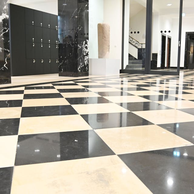Schwarz-weißer Marmorboden glänzt im Foyer des Maison Belge.