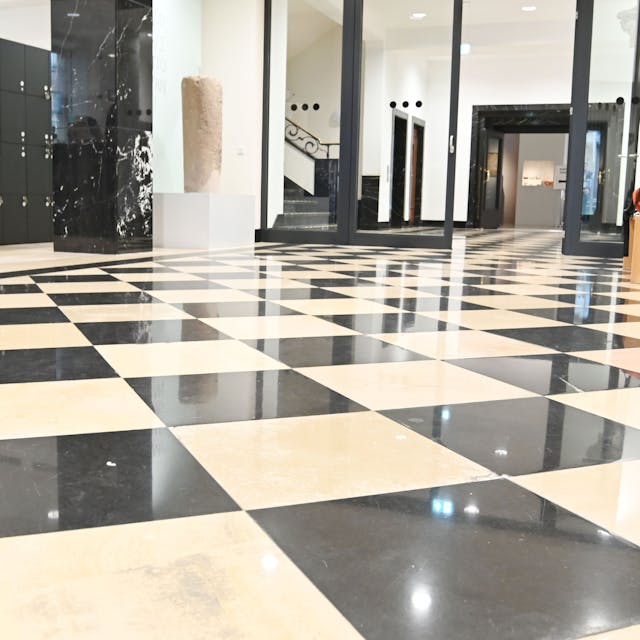 Schwarz-weißer Marmorboden glänzt im Foyer des Maison Belge.