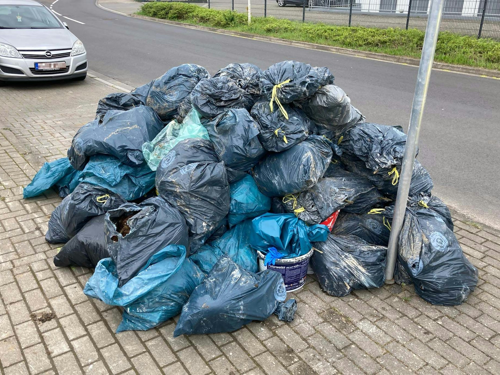 Rund 50 blaue Müllsäcke türmen sich auf der Straße
