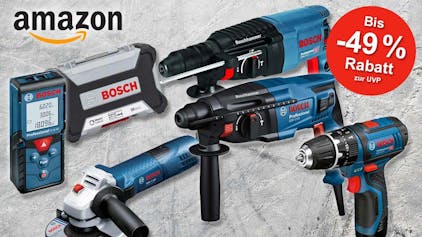 Bosch Professional Bohrhammer und Bohrmaschine, Akkuschrauber, Winkelschleifer und Laserentfernungsmessgerät, dahinter Steinmauer.