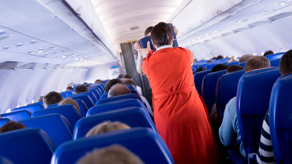 Flugbegleiterinnen verteilen an Bord eines Airbus A320 Getränke und einen kleinen Snack an die Fluggäste.