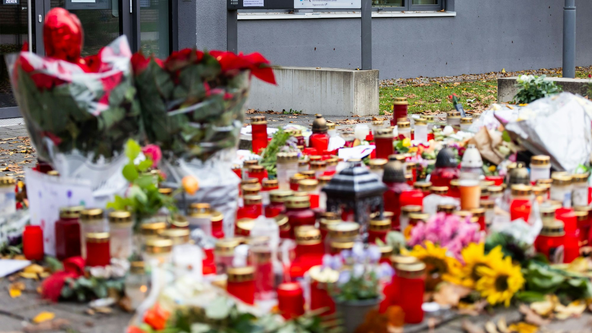 Kerzen und Blumen liegen vor dem Eingang der Waldbachschule.