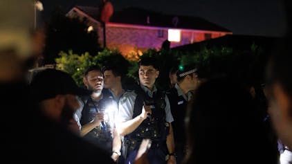 Polizisten halten Taschenlampen in der Hand.