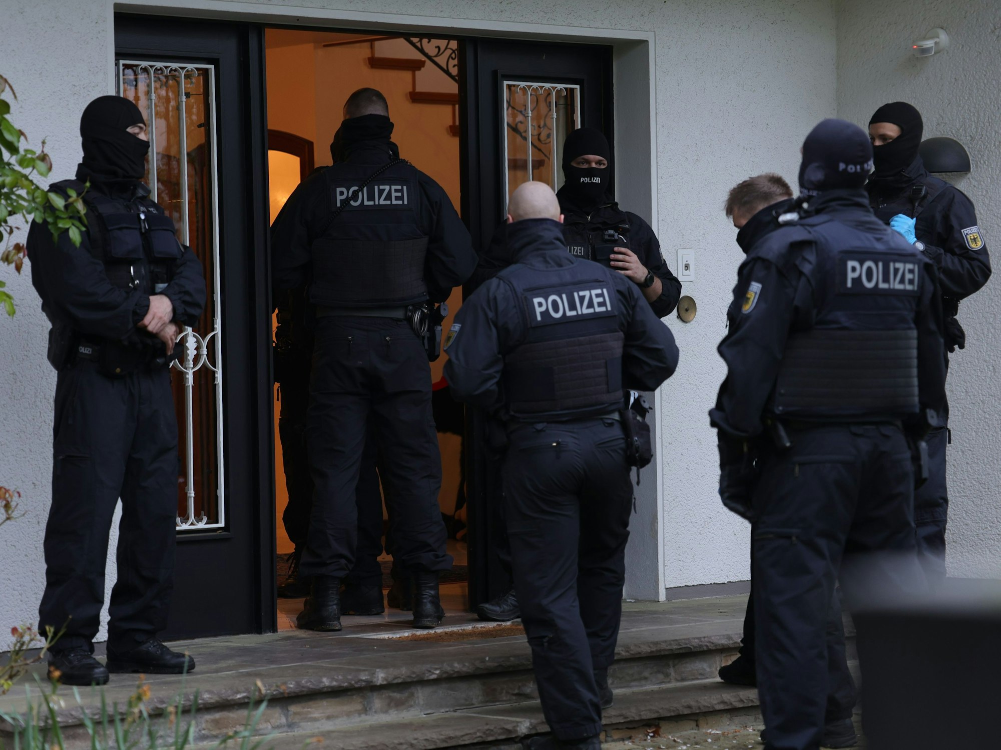 Foto von mehreren Polizeikräften, die in ein Gebäude in Solingen gehen, um es zu durchsuchen.