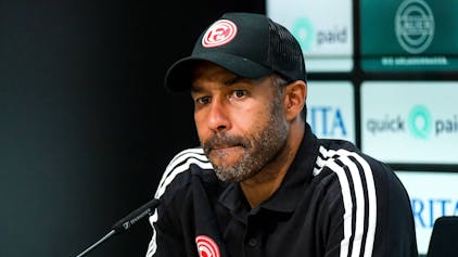 Fortuna Düsseldorfs Trainer Daniel Thioune sitzt bei der Pressekonferenz nach dem Spiel bei Wehen Wiesbaden auf dem Podium.