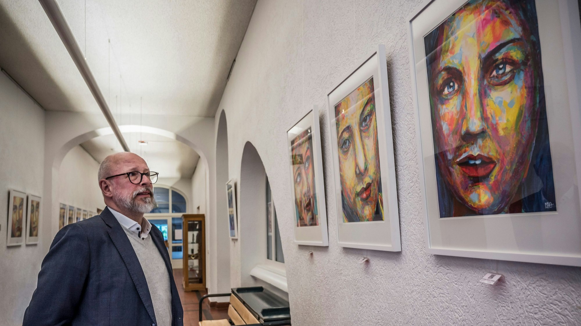 meinolf Otto und seiner Ausstellung seiner Porträtserie im Flur der Musikschule Leverkusen.