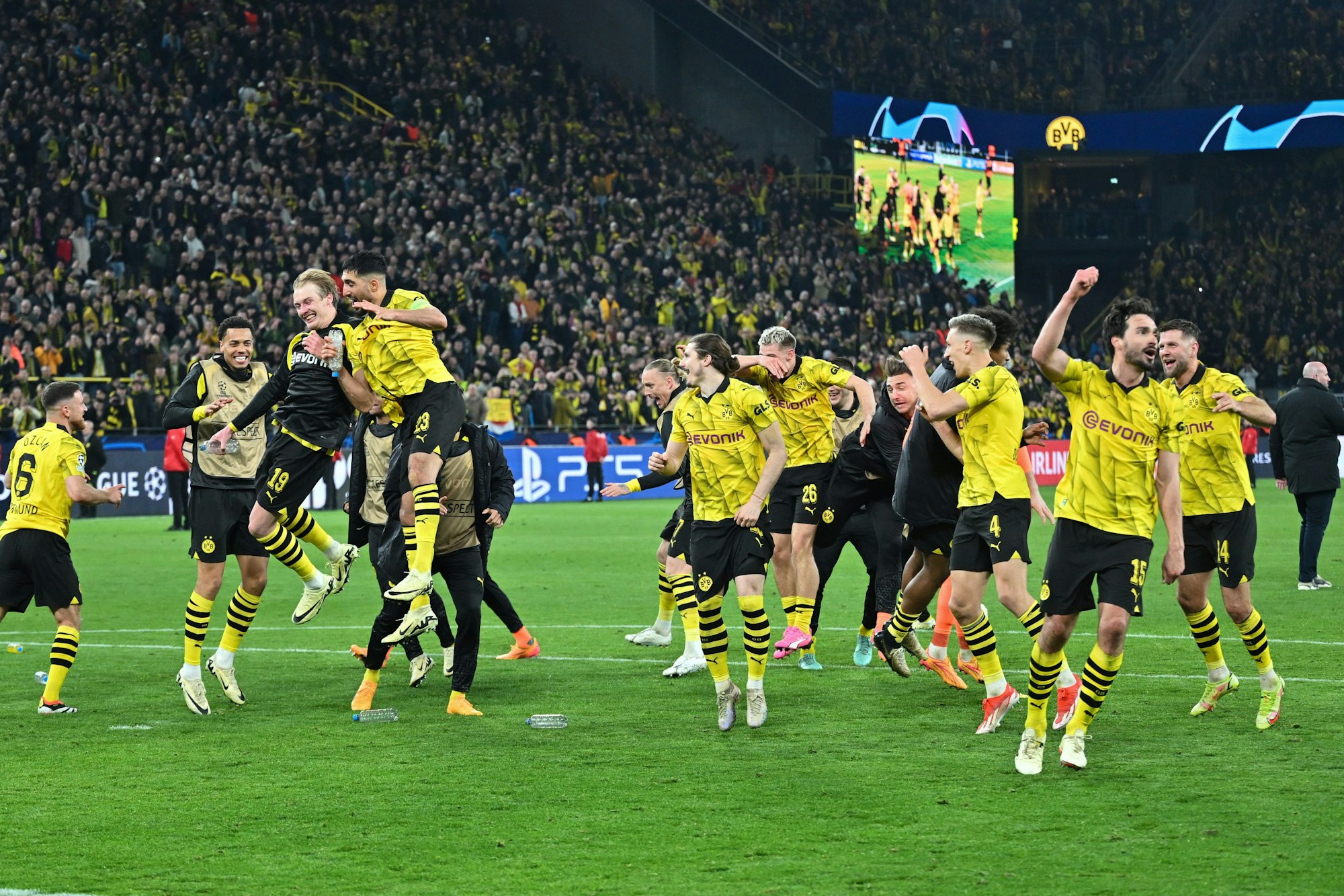 Die Dortmunder Spieler feiern ausgelassen den Einzug ins Champions League Halbfinale. Man sieht mehrere Spieler lachen und springen und im Hintergrund den vollbesetzten Signal-Iduna-Park.