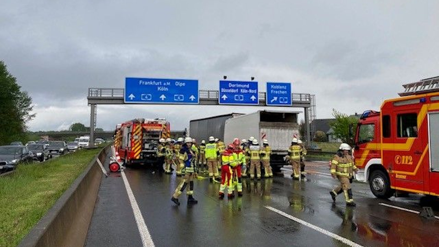 Auf der Autobahn stehen zwei Lkw ineinander geschoben. Darum herum stehen Feuerwehr-Autos und Feuerwehrleute und Rettungskräfte.