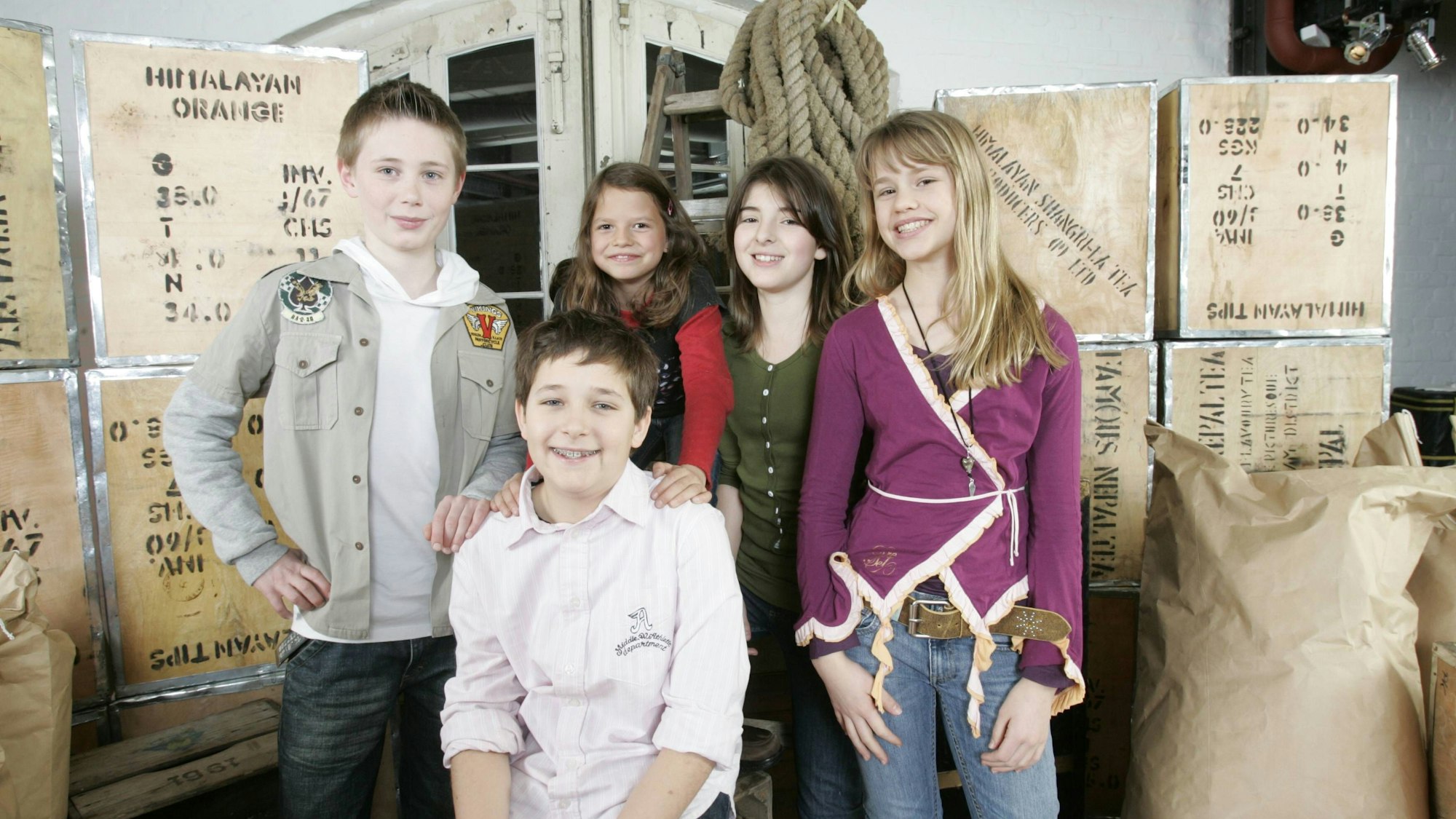 Fünf Kinder posieren für ein Foto in einem TV-Studio.