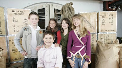 Fünf Kinder posieren für ein Foto in einem TV-Studio.