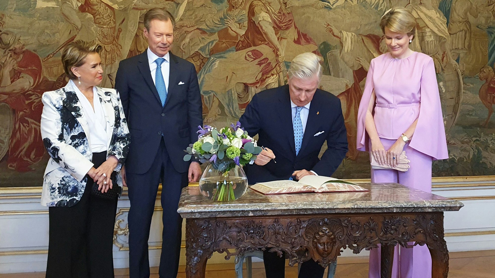 Königin Mathilde von Belgien (r), Großherzog Henri (m-l), König Philippe (m-r) und Großherzogin Maria Teresa (l) tragen sich beim Besuch in Lüttich in das Goldene Buch ein.