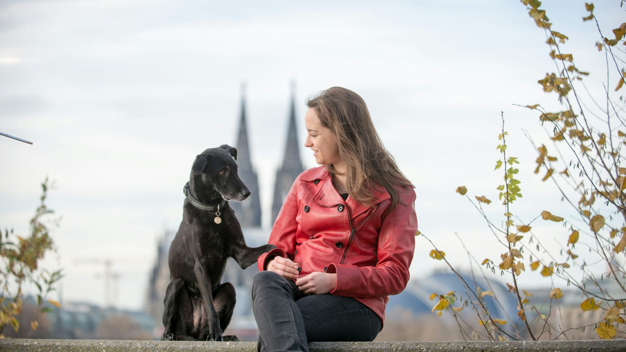 Dominique Tordy mit einem Hund vor dem Kölner Dom