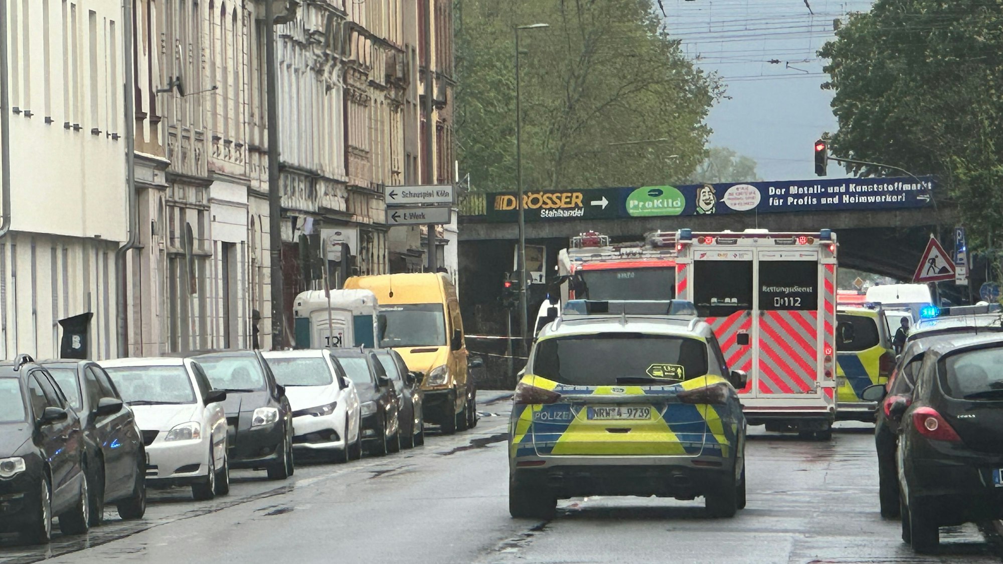 Ein Streifenwagen, ein RTW und ein Feuerwehrfahrzeug stehen auf einer Straße.