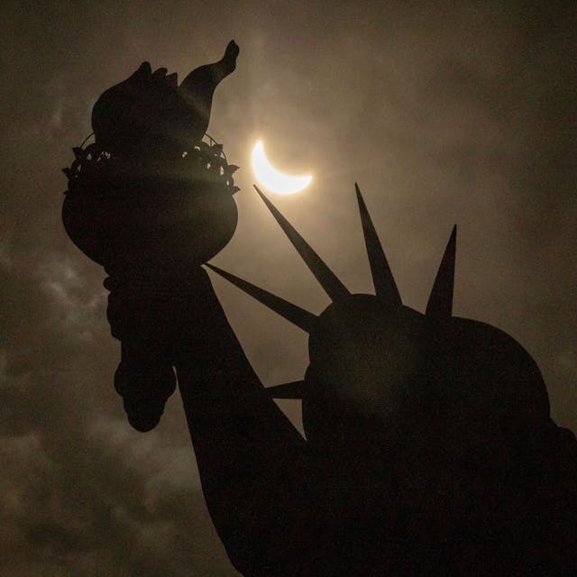8, April 2024,&nbsp; USA, New York: Der Mond verdeckt teilweise die Sonne hinter der Freiheitsstatue während der totalen Sonnenfinsternis auf Liberty Island.