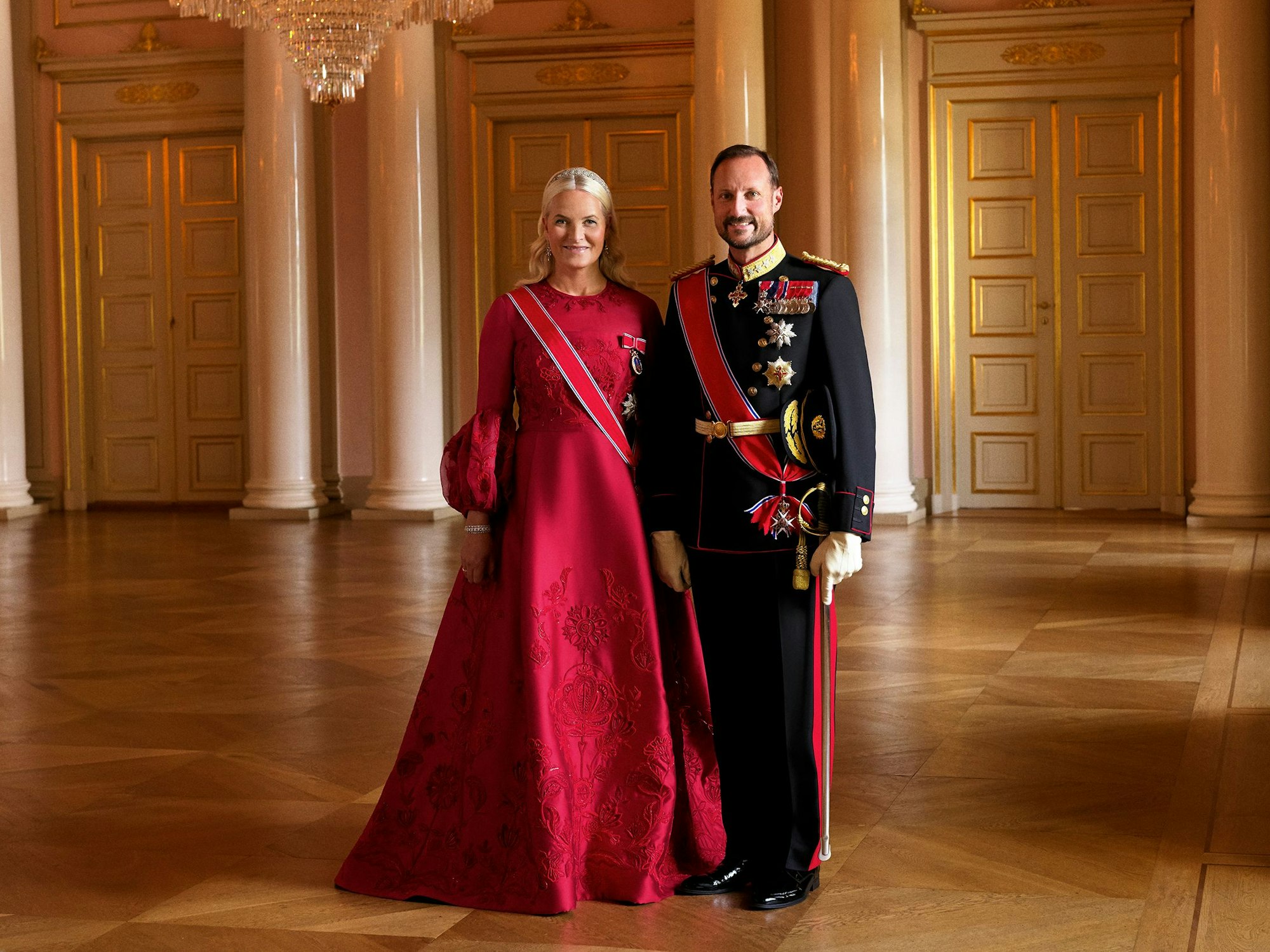 Prinzessin Mette-Marit und Kronprinz Haakon stehen im Palast.