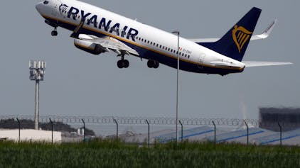 Eine Boeing 737 der Fluggesellschaft Ryanair startet hinter einer grünen Wiese vom Flughafen Berlin-Brandenburg (BER) „Willy Brandt“, hier im Mai 2023.