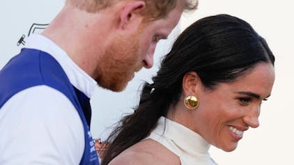 Der britische Prinz Harry und seine Frau Meghan Markle, Herzogin von Sussex, halten sich an den Händen, als sie die Bühne nach der Preisverleihung der Royal Salute Polo Challenge 2024 zugunsten von Sentebale verlassen.&nbsp;