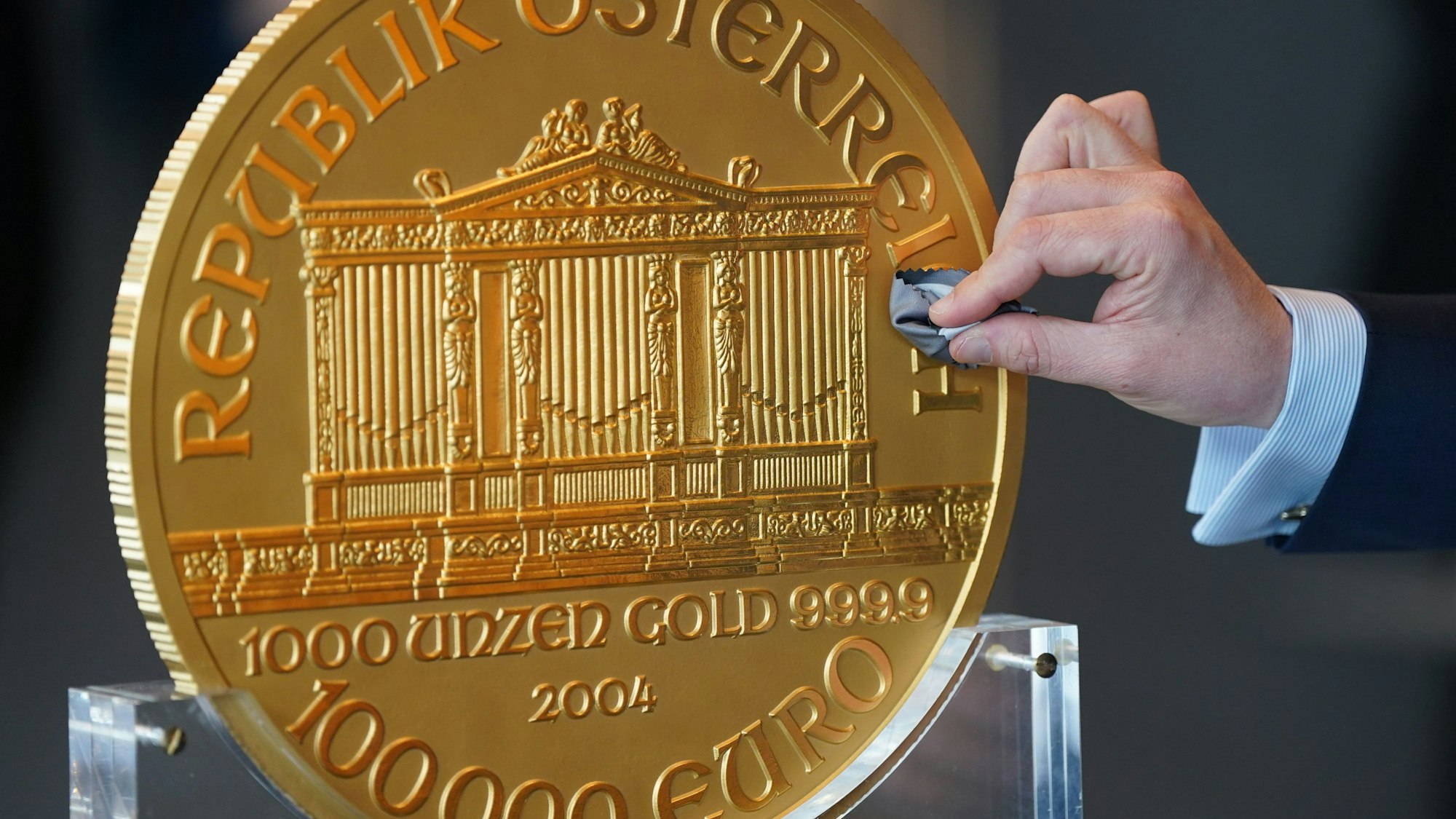 Alexander Köhne, Vertriebsleiter Pro Aurum, putzt während eines Pressetermins eine ca. 31 Kilogramm schwere und im Durchmesser etwa 37 Zentimeter große Goldmünze.