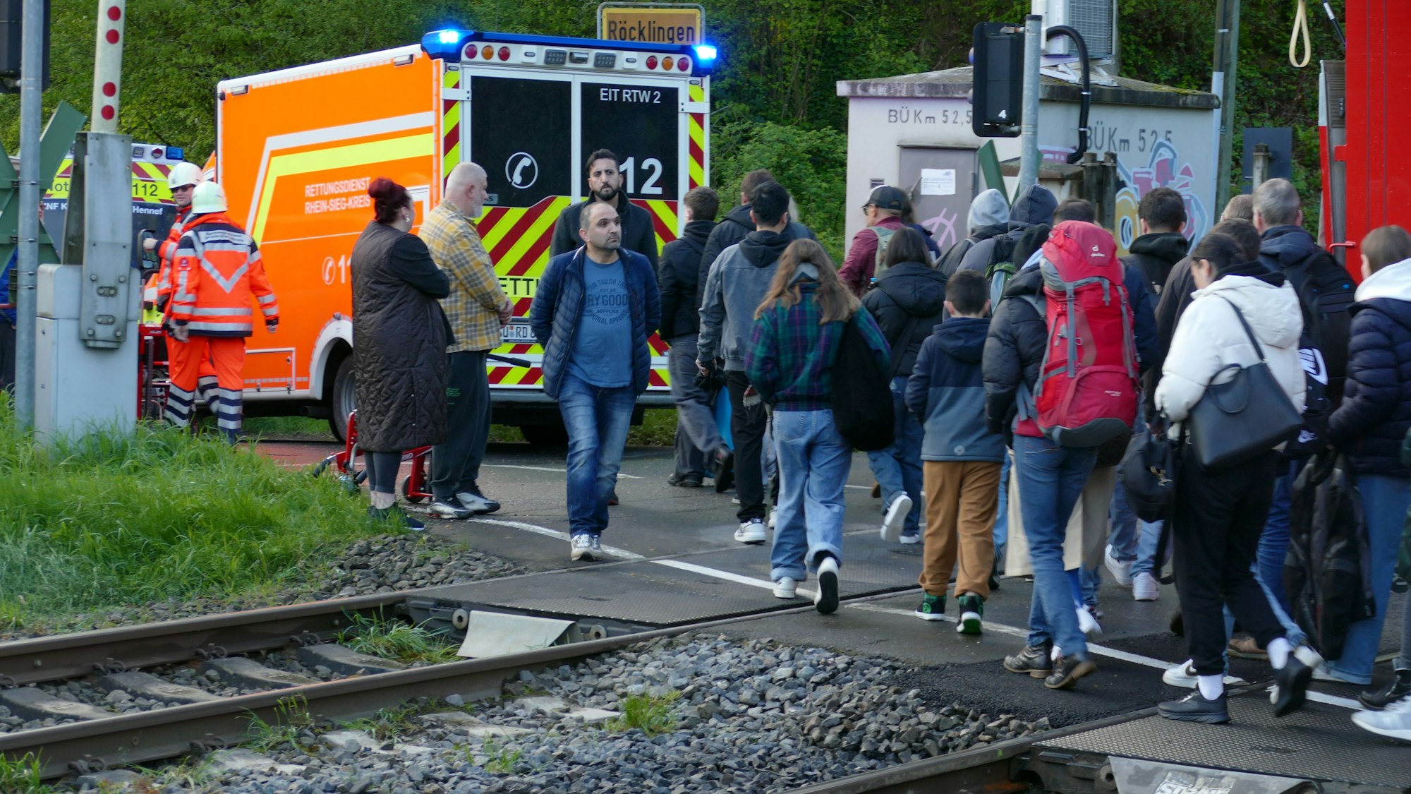 Eine Gruppe von Menschen steigt in Busse um, nachdem sie aus einem Zug evakuiert wurde.