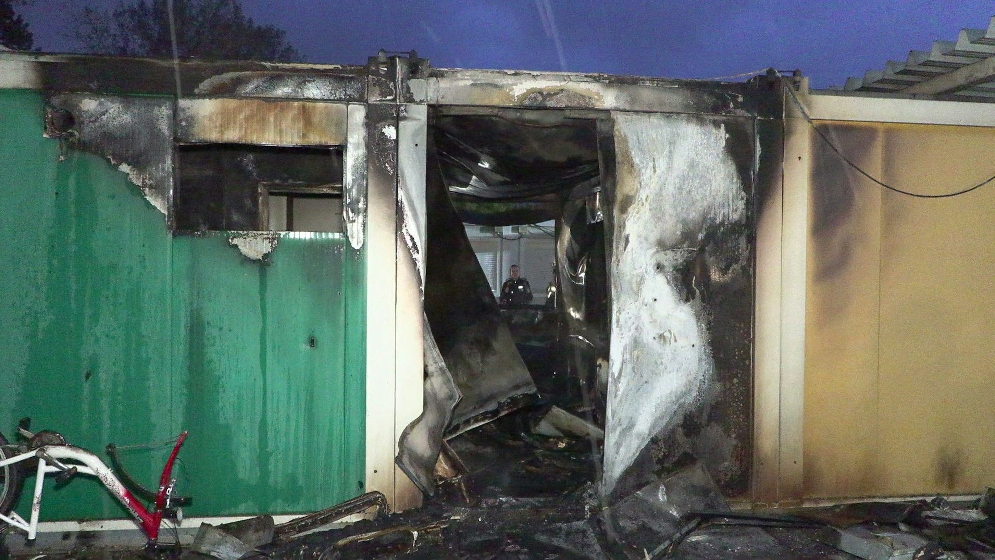 Blick in einen vollständig durch einen Brand zerstörten Flüchtlingscontainer.