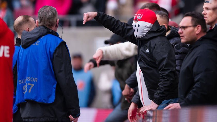 Anhänger des 1. FC Köln gestikulieren nach der Partie am Spielfeldrand in Richtung der Mannschaft und teilen ihren Ärger über die Niederlage.