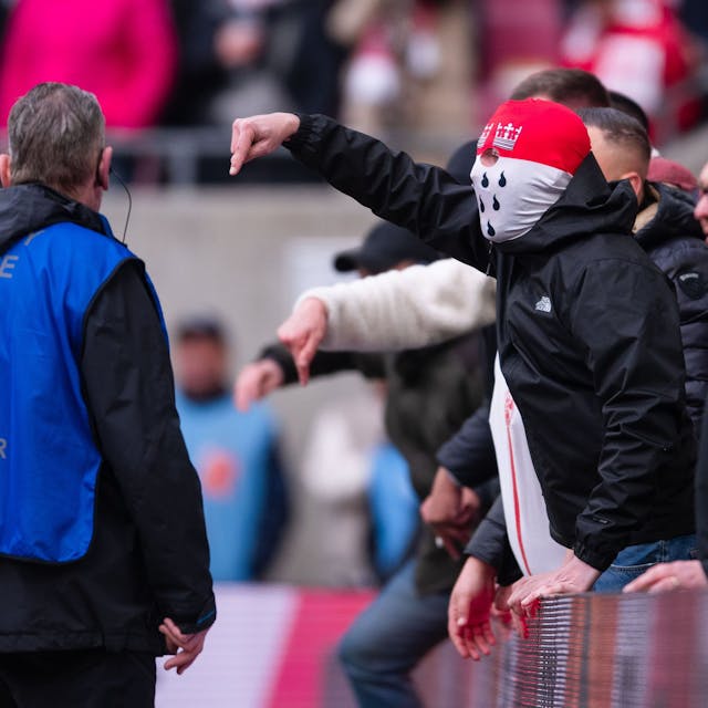 Anhänger des 1. FC Köln gestikulieren nach der Partie am Spielfeldrand in Richtung der Mannschaft und teilen ihren Ärger über die Niederlage.