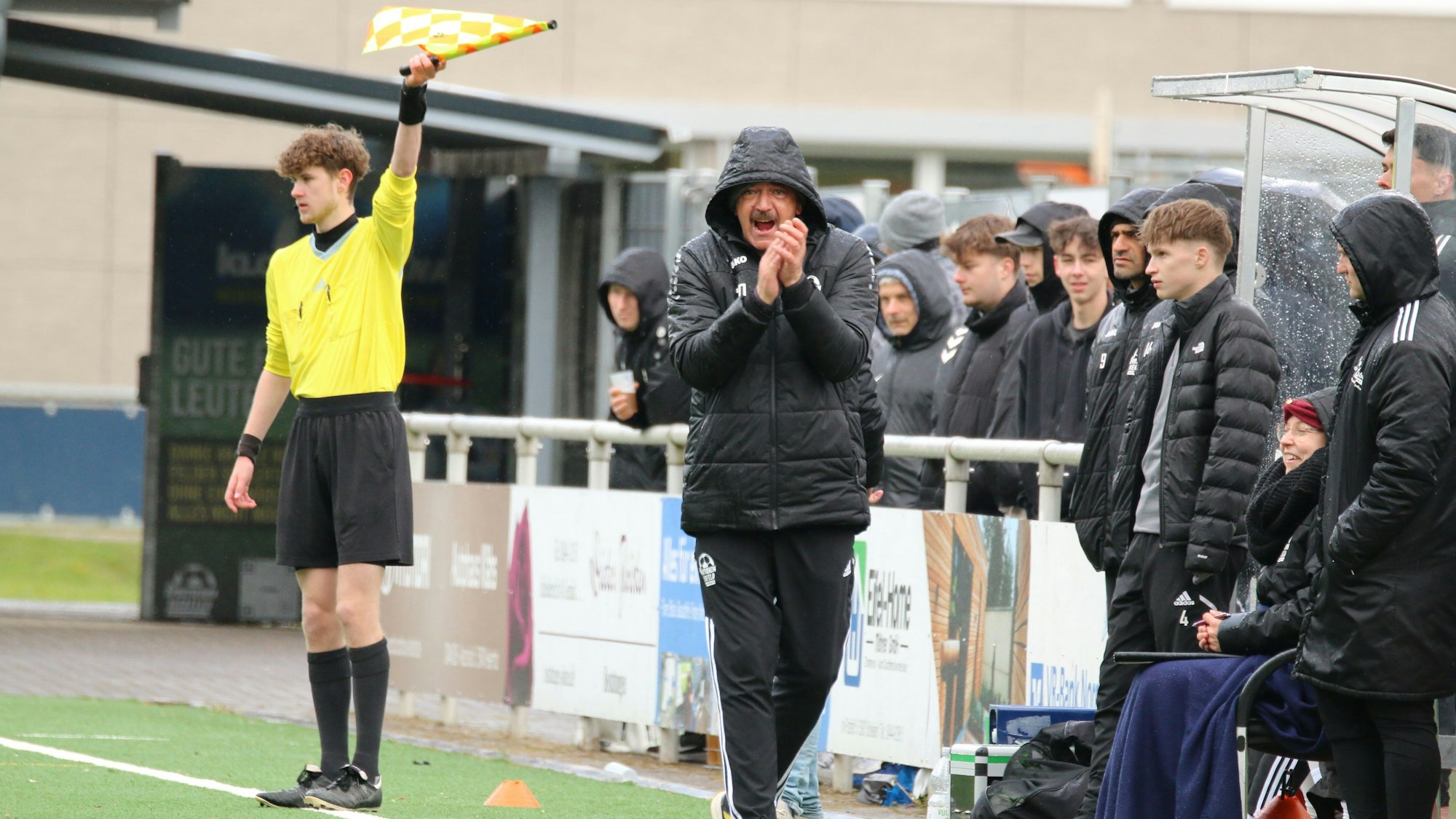 Nierfelds Trainer Dirk Scheer klatscht, die Kapuze hängt ihm über dem Kopf. Im Hintergrund winkt der Linienrichter mit der Fahne.