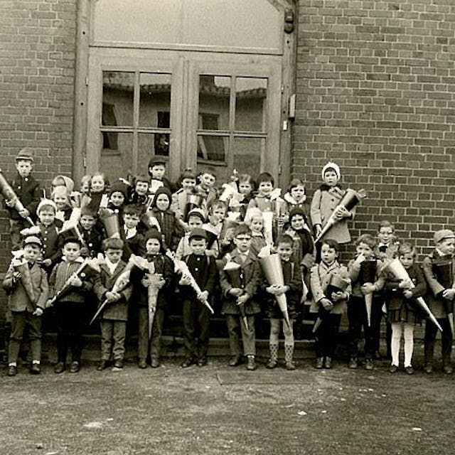 Ein Schwarzweißfoto zeigt Kinder mit Schultüten vor einem Schulgebäude. Das Foto ist vor 60 Jahren entstanden.