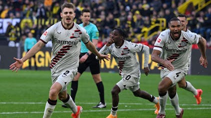 Die Spieler von Bayer Leverkusen bejubeln mit Josip Stanisic den späten Ausgleichstreffer.