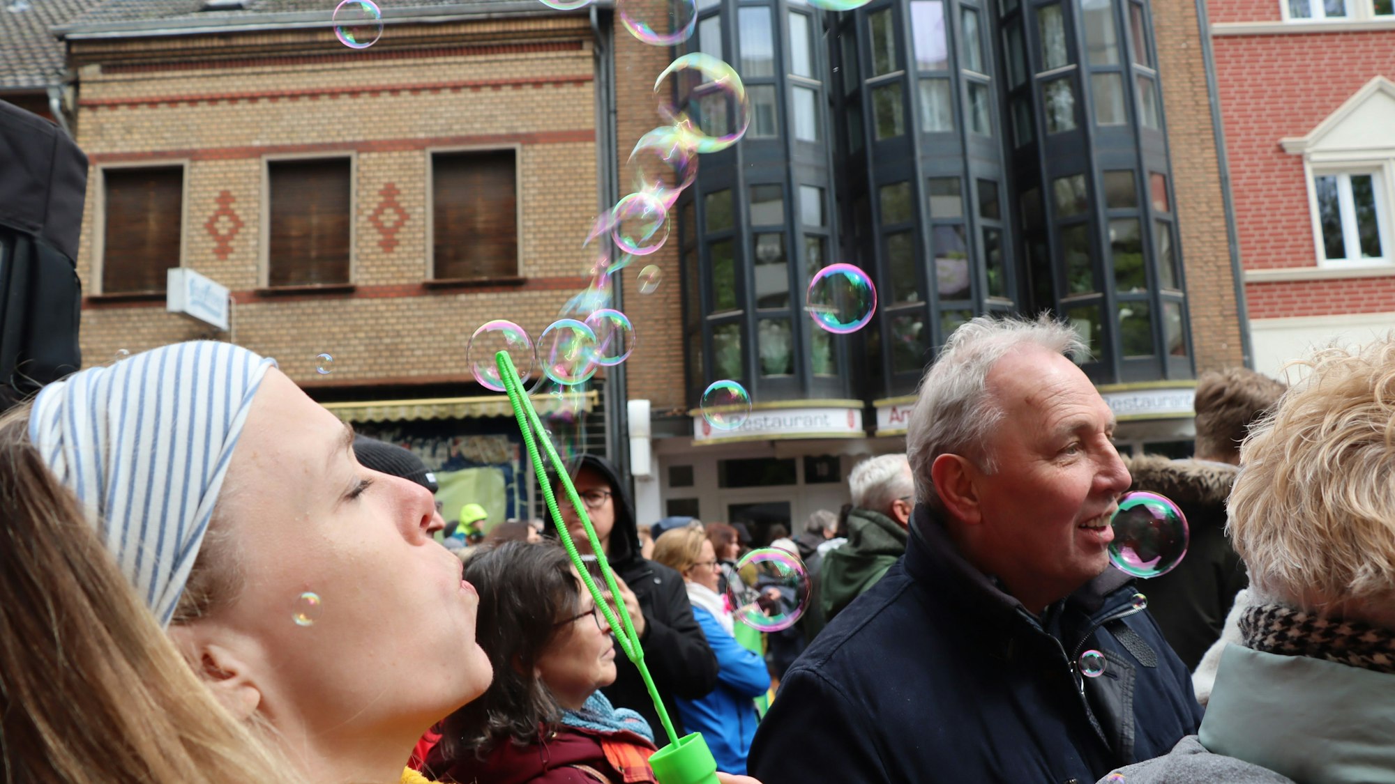 Auf dem Foto ist eine junge Frau zu sehen, die Seifenblasen erzeugt.