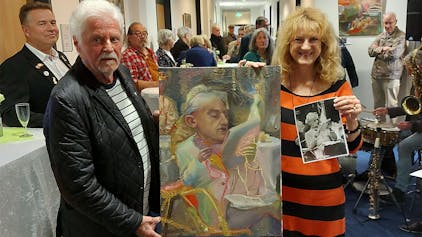 Kruse und Franke halten bei der Ausstellungseröffnung ein Gemälde von Mona Dia.