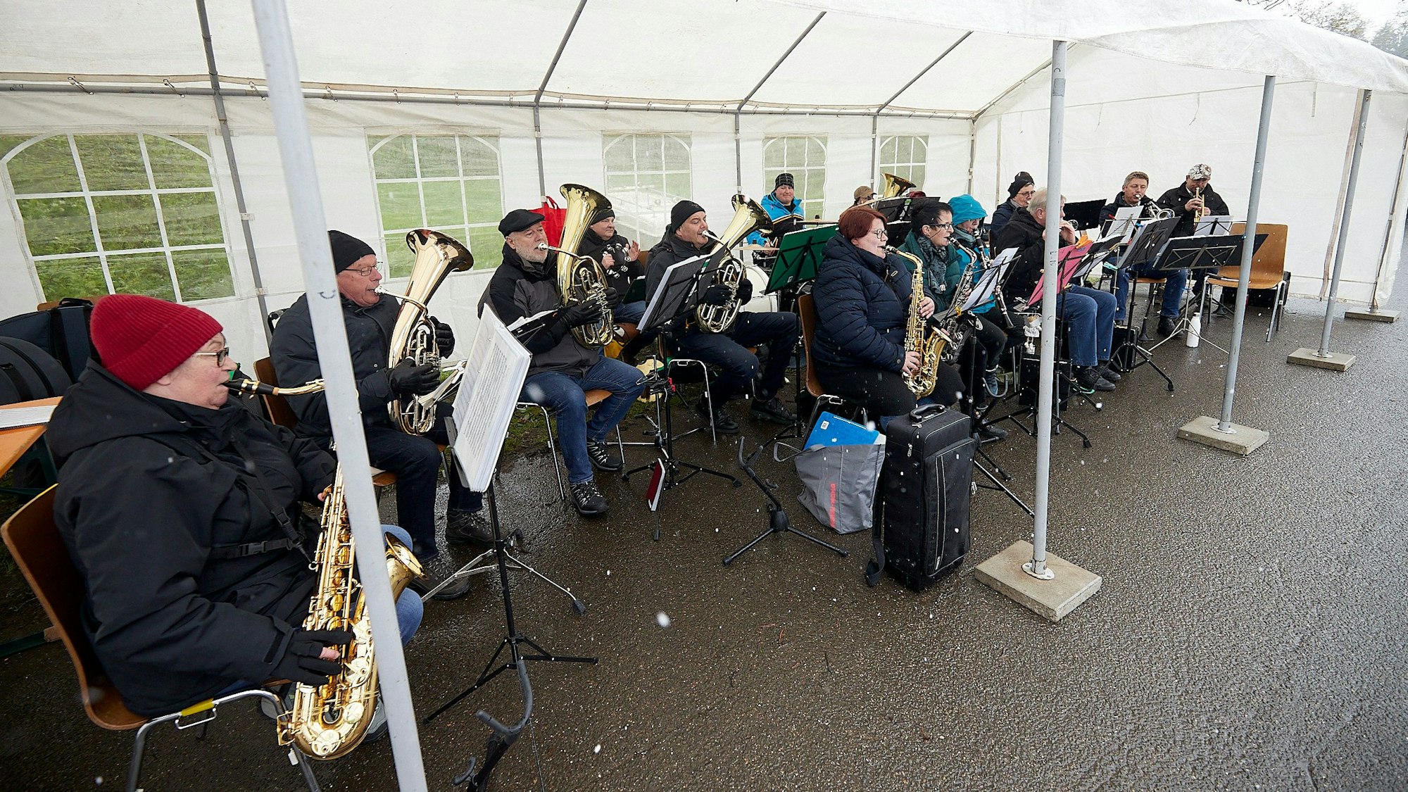 Musiker des Musikvereins Reifferscheid sitzen in Winterkleidung beim Musizieren unter einem Pavillon.