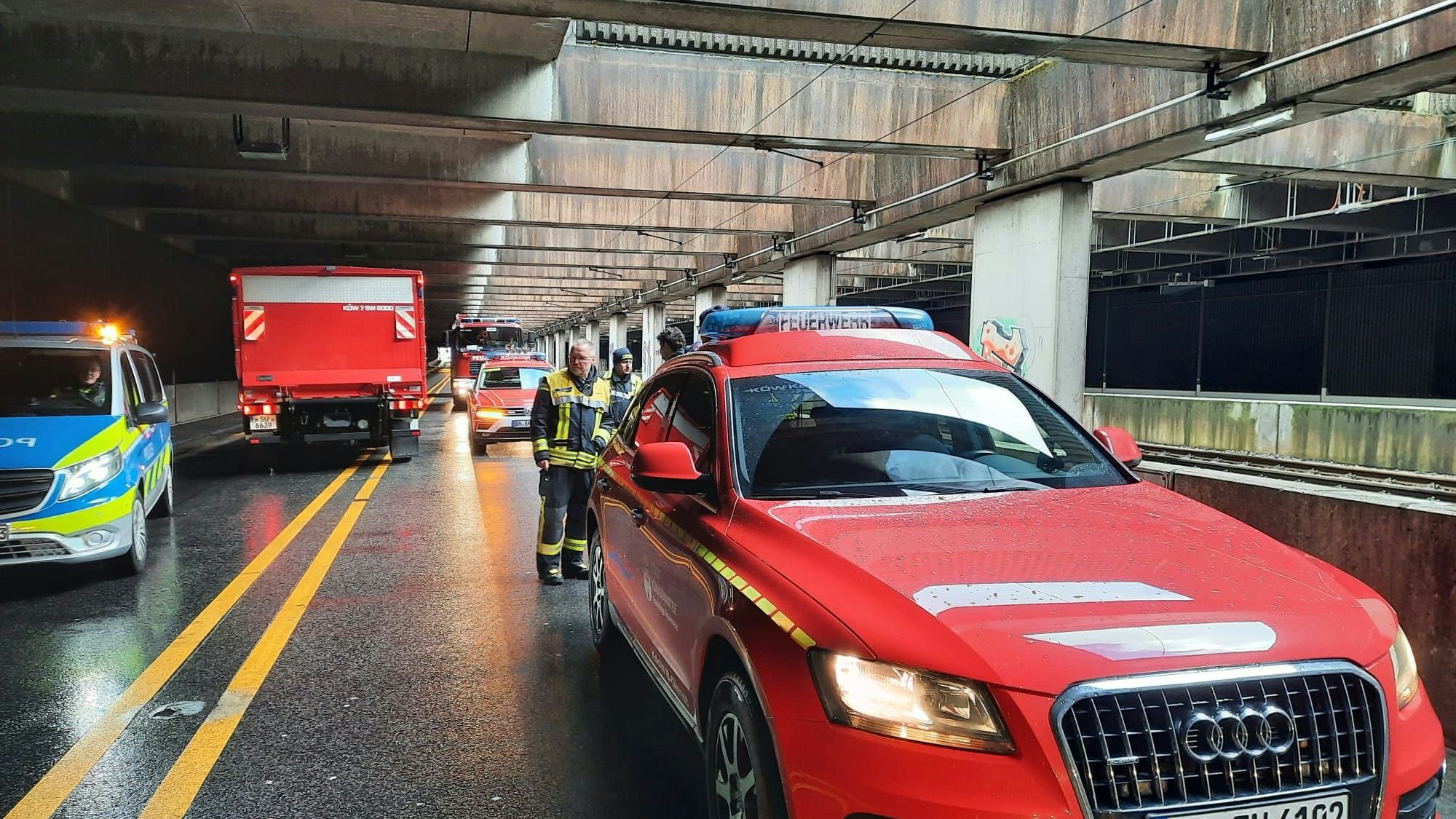 Einsatzfahrzeuge der Polizei und der Feuerwehr stehen am Eingang eines Straßentunnels.