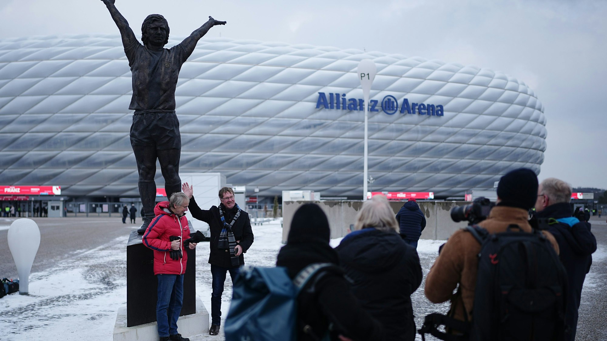 Besucher stehen vor der Gerd-Müller-Statue vor der Trauerfeier für den verstorbenen Fußballstar und Trainer Beckenbauer.