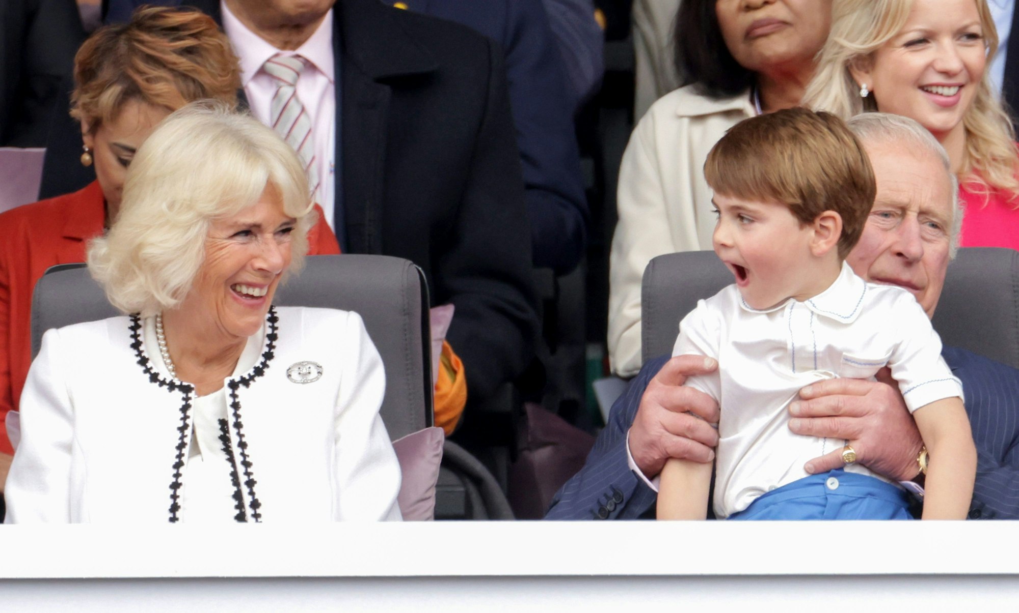 Camilla lacht über den kleinen Prinzen Louis, der auf dem Schoß seines Großvaters, des heutigen Königs Charles, sitzt.