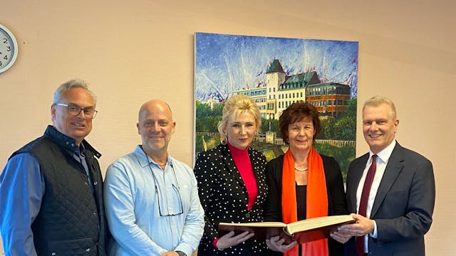 Der Vorstand der aufgelösten Innenstadtgemeinschaft Porz trägt sich ins Ehrenbuch des Stadtbezirks ein.