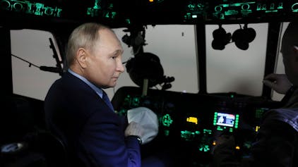 Auf diesem von der nationalen Nachrichtenagentur Sputnik via AP veröffentlichten Foto sitzt der russische Präsident Wladimir Putin Ende März 2024 im Cockpit eines Hubschraubers: Laut britischen Medien soll der Kreml britische Urlaubsflüge mit einem Störsender angegriffen haben.