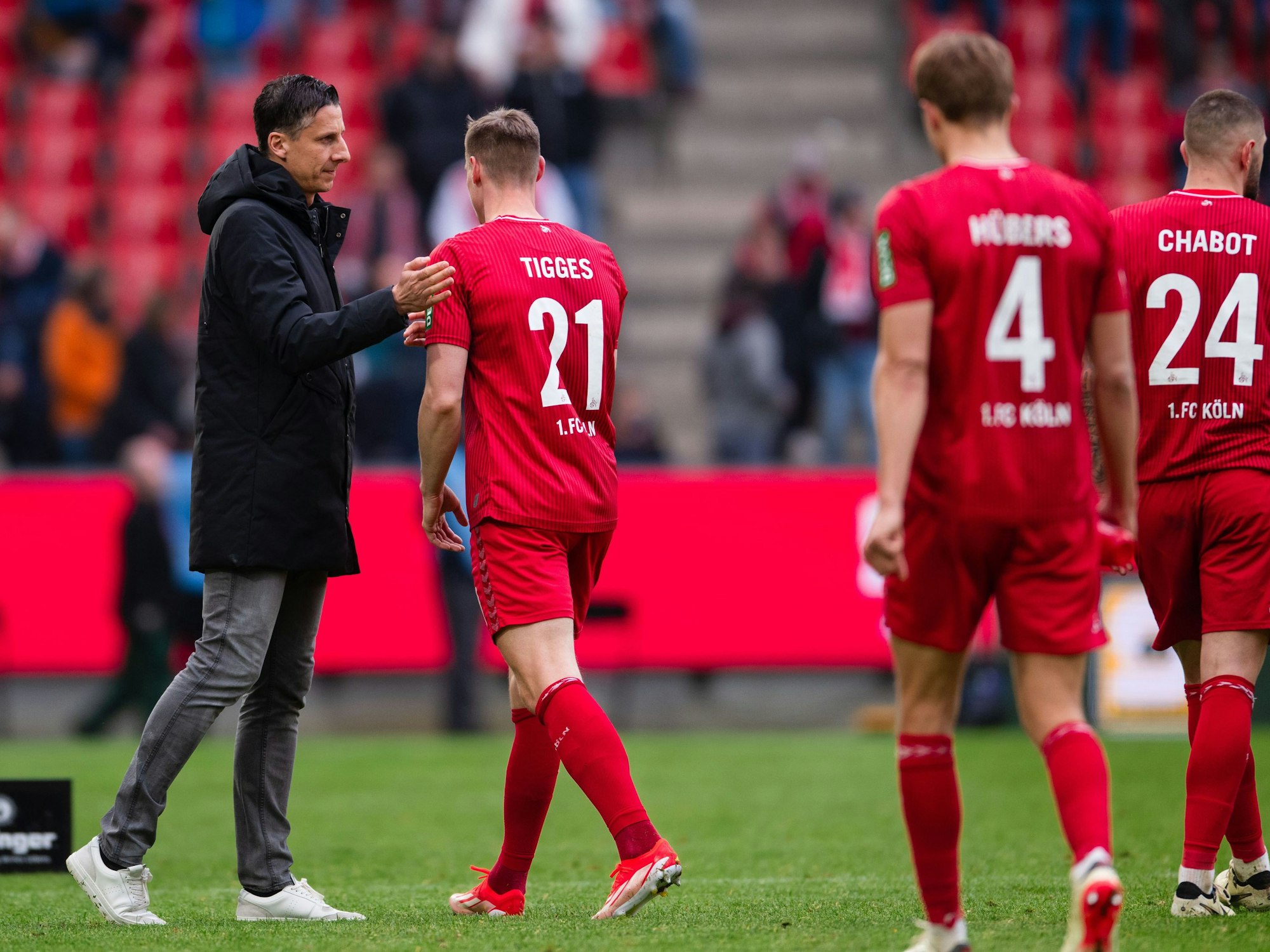 Kölns Sportdirektor Christian Keller (l) klatscht nach der Partie Steffen Tigges ab.